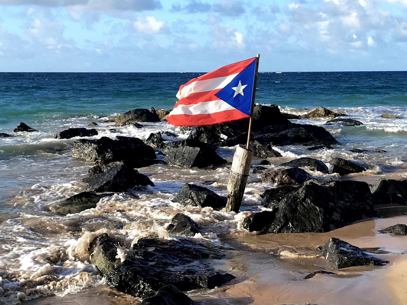 The Puerto Rico Flag Flies On The Beach In Condado A Neighborhood Of San Juan Wjct Public Media